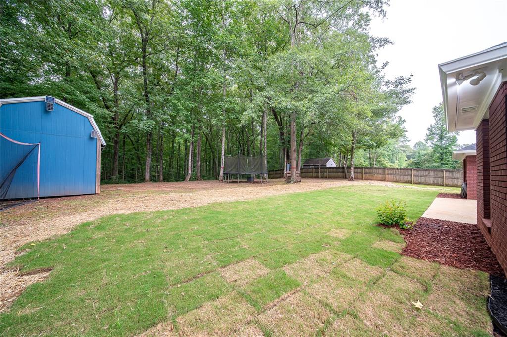 1927 Lee Road Salem, AL 36874 - Photo 5 of 45 Fenced backyard with a trampoline and a storage unit