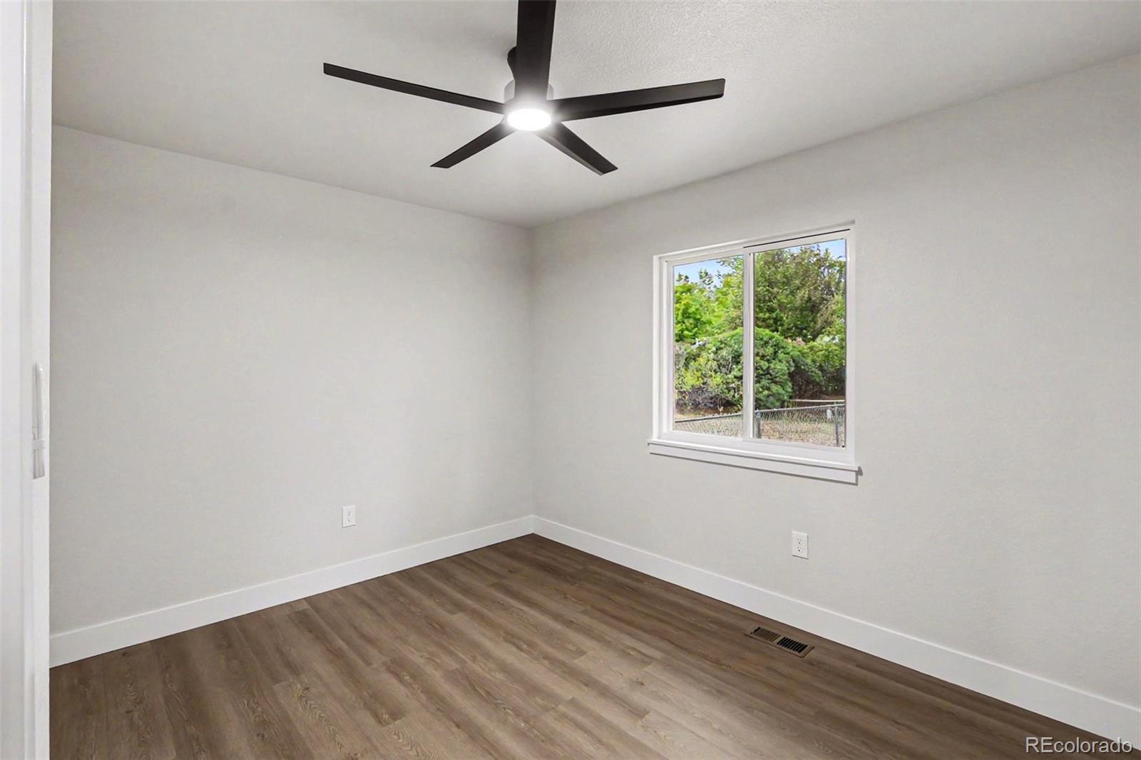 809 Gallup Road Fort Collins, CO 80521 - Photo 14 of 20 an empty room with wooden floor and windows