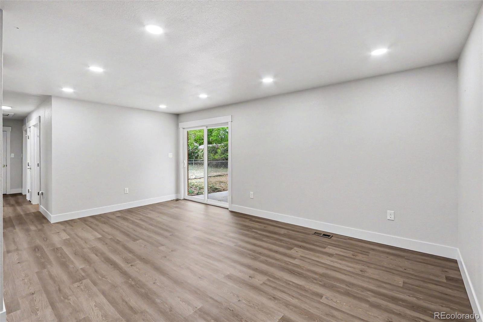 809 Gallup Road Fort Collins, CO 80521 - Photo 7 of 20 an empty room with wooden floor and windows