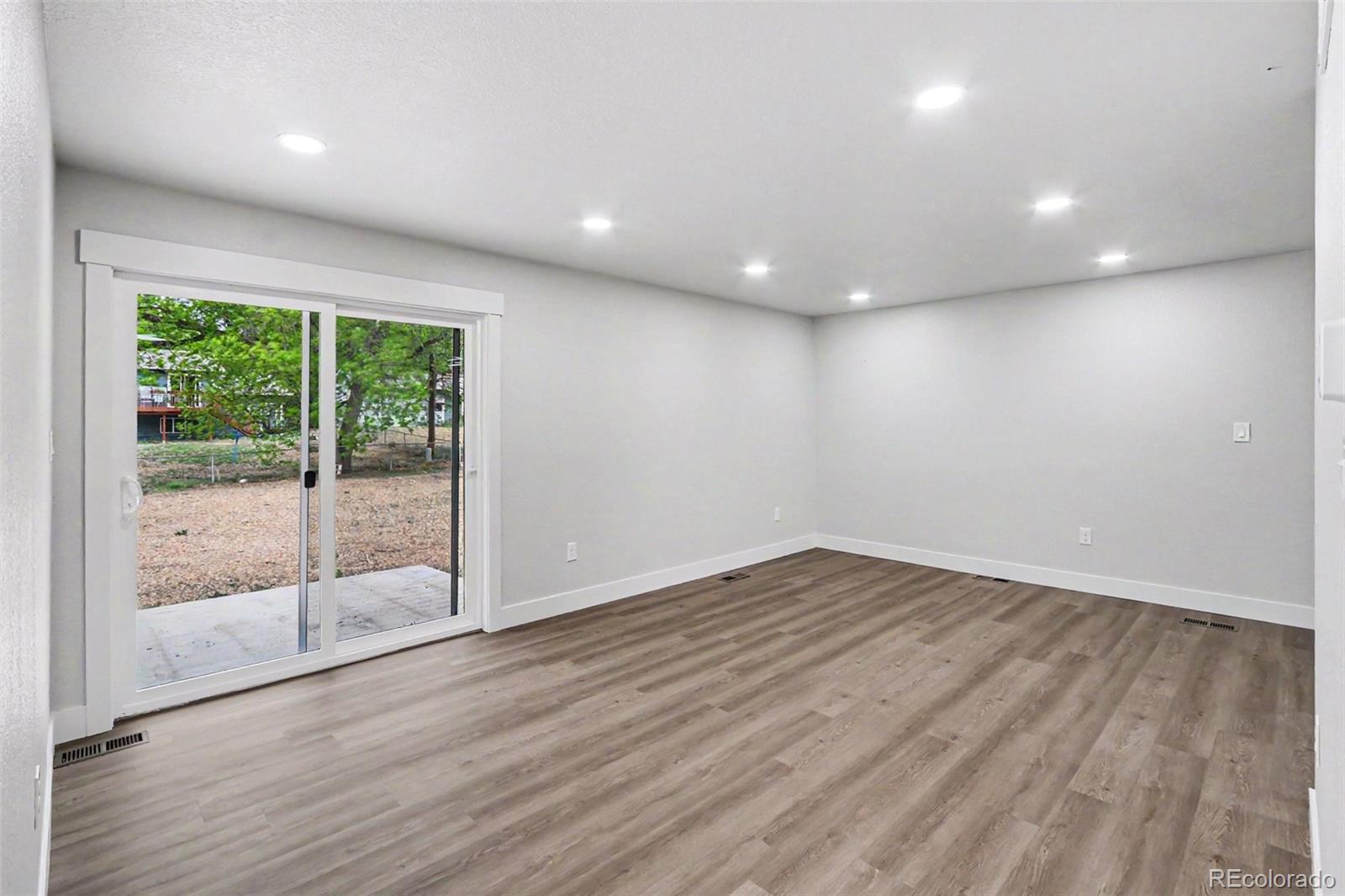 809 Gallup Road Fort Collins, CO 80521 - Photo 8 of 20 an empty room with wooden floor and windows