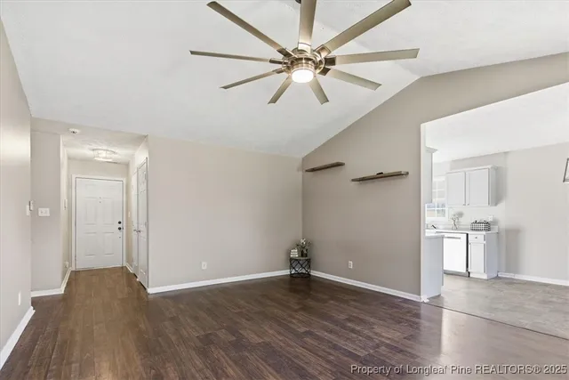 an empty room with wooden floor and ceiling fan