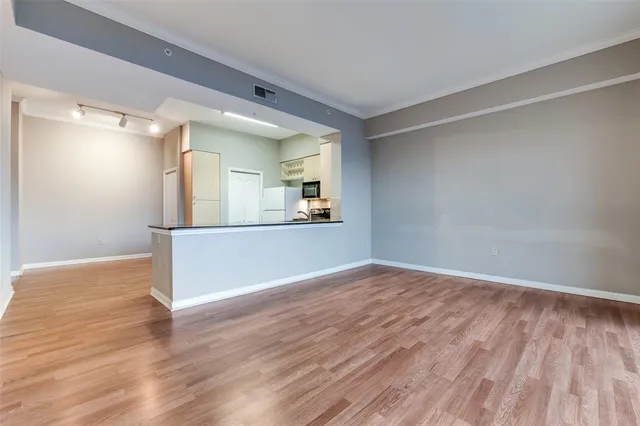 a view of a kitchen with wooden floor and a window