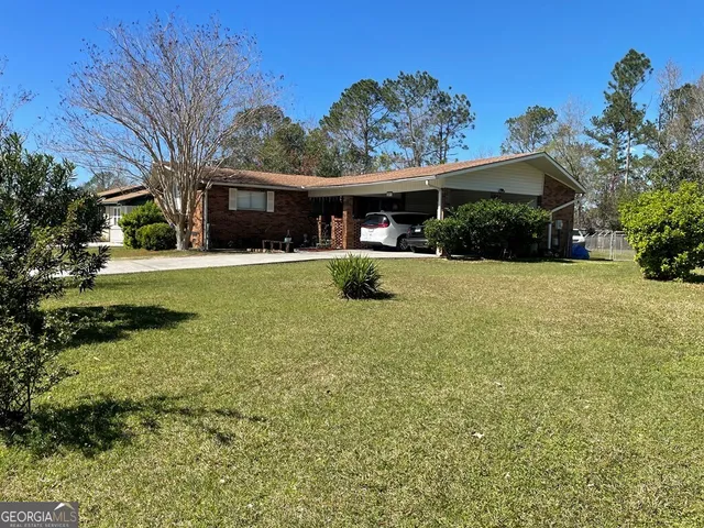a view of a house with a big yard and large trees