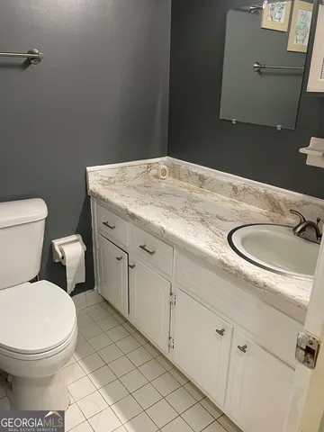 a bathroom with a granite countertop toilet and sink
