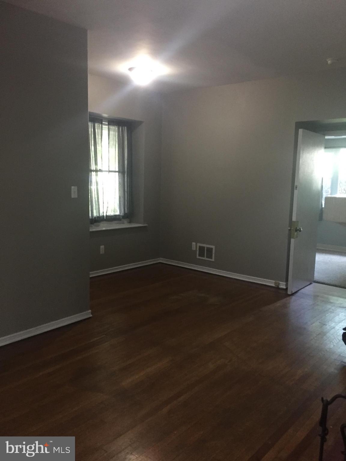 6357 Lancaster Avenue Philadelphia, PA 19151 - Photo 4 of 27 an empty room with wooden floor and windows