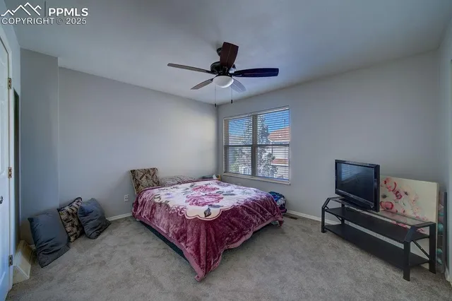 a bedroom with a bed and a ceiling fan