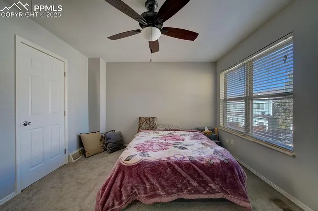 a bedroom with a bed and a large window