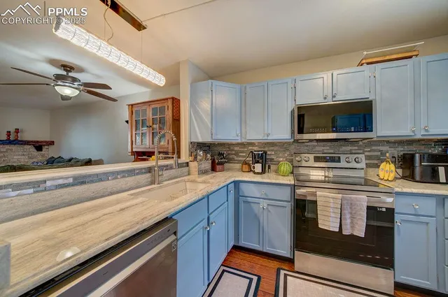 a kitchen with stainless steel appliances granite countertop a sink a stove and cabinets