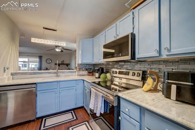 a kitchen with stainless steel appliances granite countertop a sink stove and microwave
