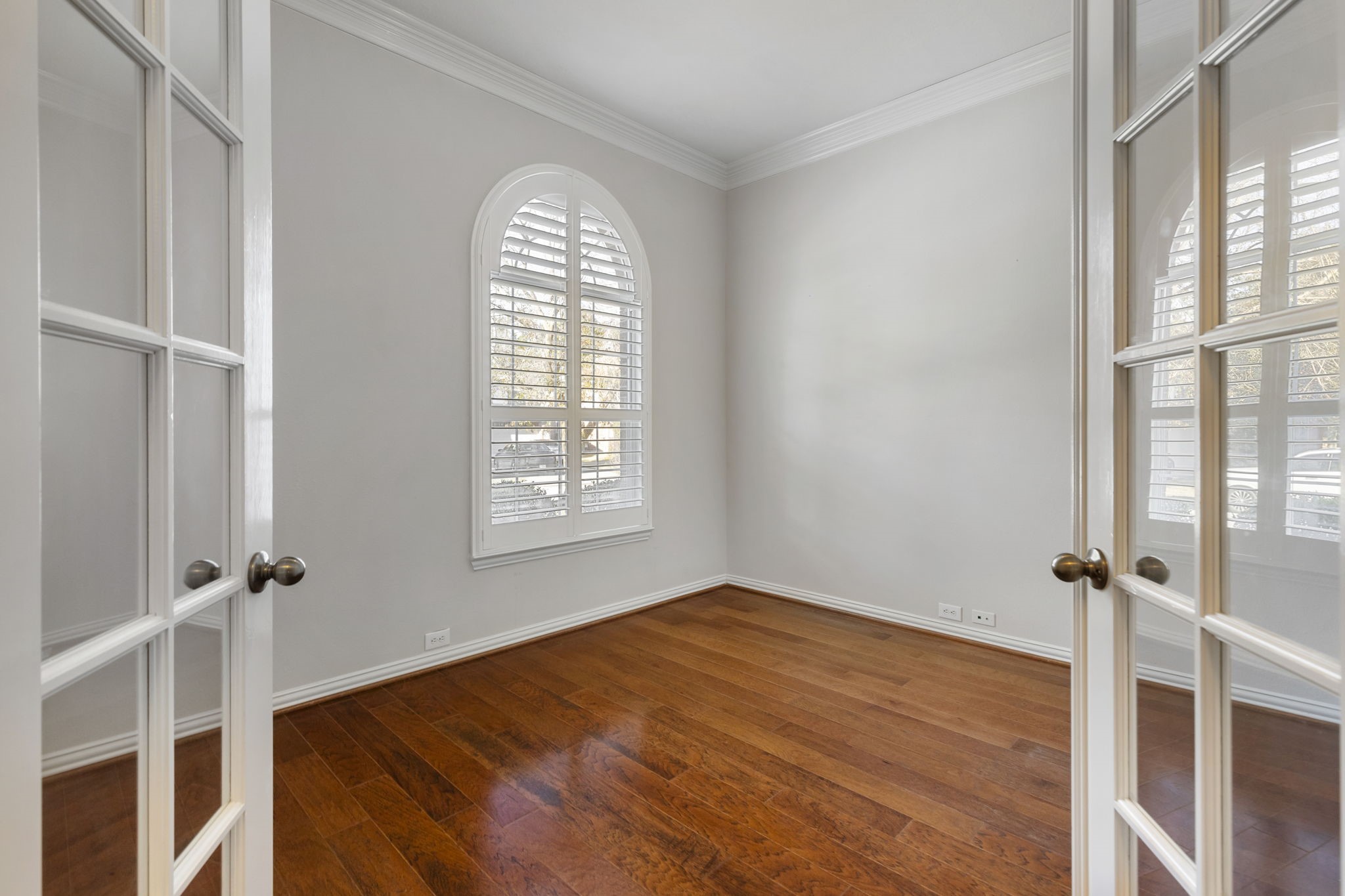80 North Frontera Circle Spring, TX 77382 - Photo 3 of 28 Lovely study or flex room with double French doors. Features an arched window with shutters, providing a classic and elegant touch.