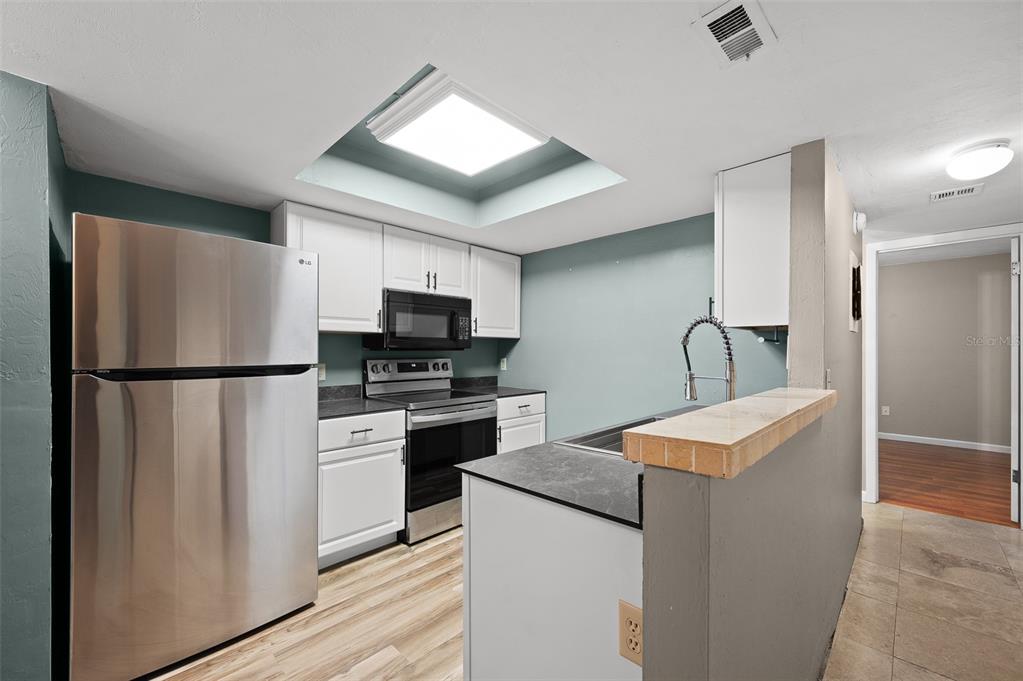 2508 Southwest 35th Place, Unit 151 Gainesville, FL 32608 - Photo 2 of 19 a kitchen with stainless steel appliances a refrigerator stove and microwave