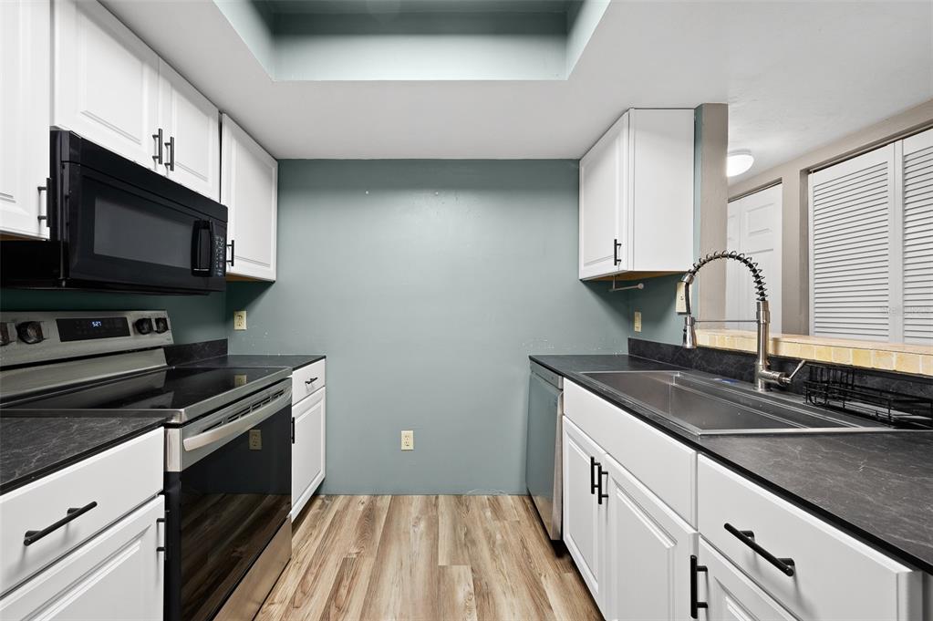 2508 Southwest 35th Place, Unit 51 Gainesville, FL 32608 - Photo 5 of 20 a kitchen with stainless steel appliances granite countertop a sink stove and microwave