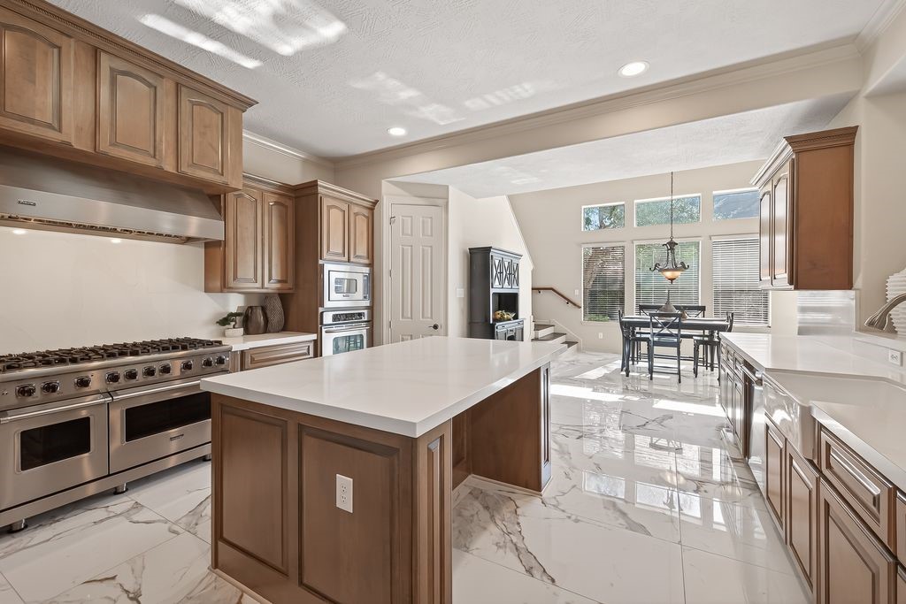 8115 Salta Verde Point Katy, TX 77494 - Photo 18 of 50 a kitchen with stainless steel appliances a stove a sink cabinets and a refrigerator