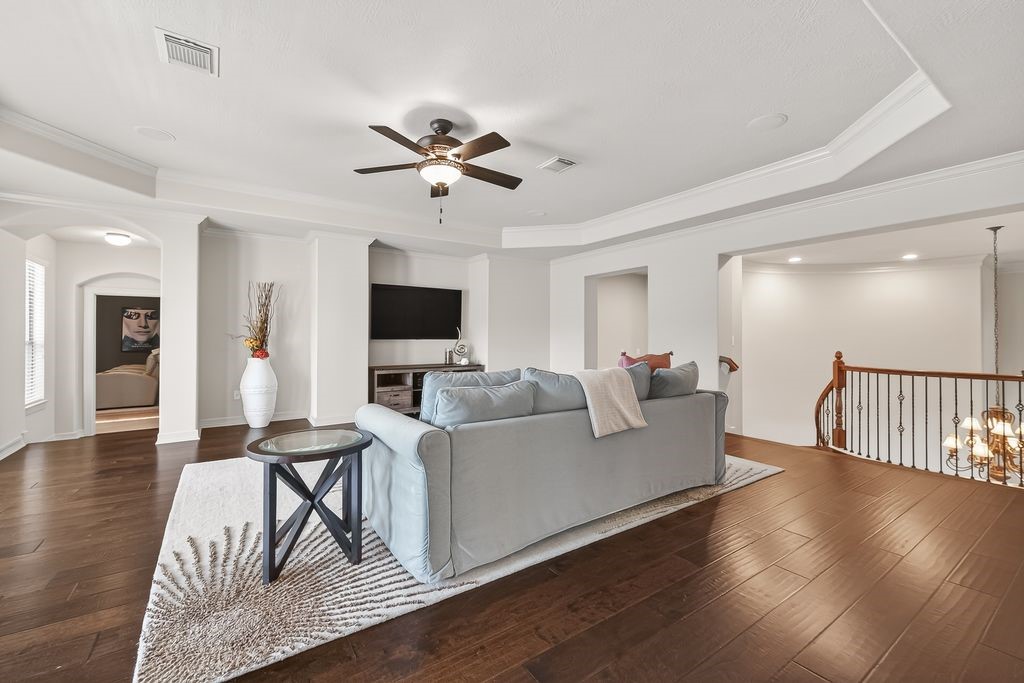 8115 Salta Verde Point Katy, TX 77494 - Photo 34 of 50 a living room with furniture a wooden floor and a flat screen tv