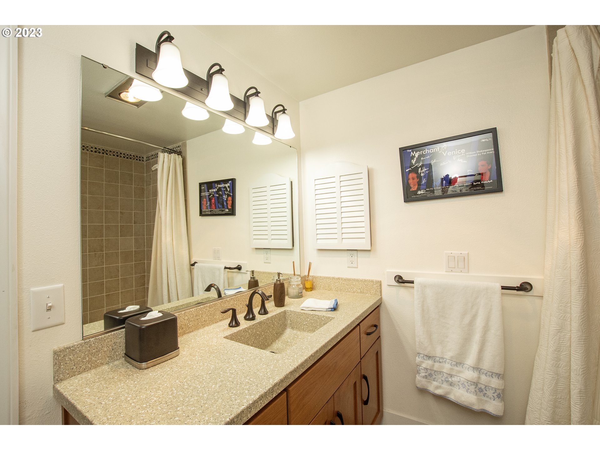 197 Brae Burn Drive Eugene, OR 97405 - Photo 16 of 42 a bathroom with a sink a mirror and a painting on the wall