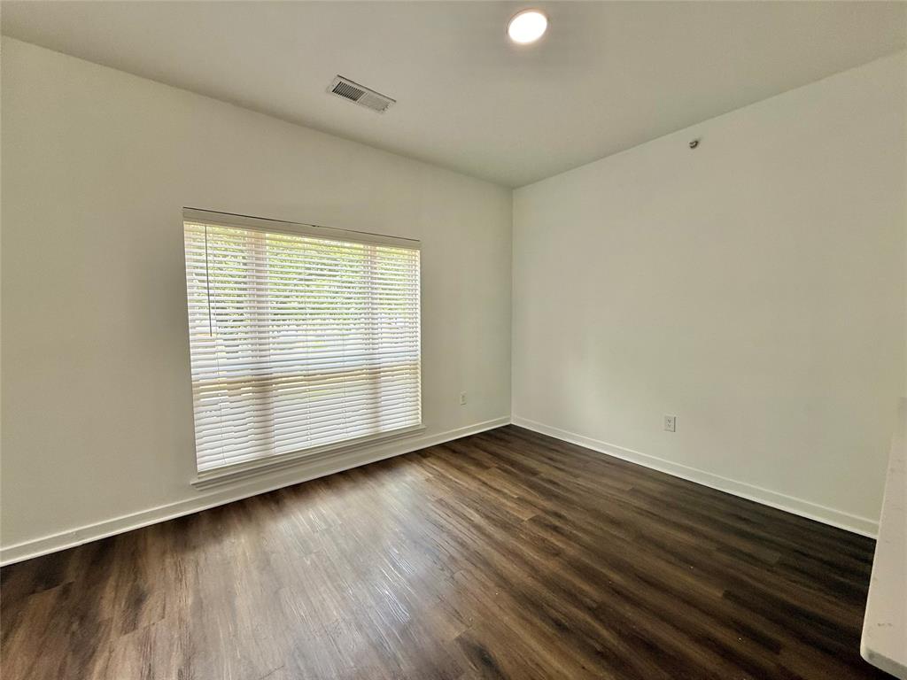 6740 Windhaven Parkway, Unit 5907 The Colony, TX 75056 - Photo 11 of 20 an empty room with wooden floor and windows