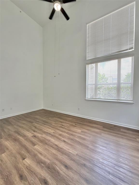 6740 Windhaven Parkway, Unit 5907 The Colony, TX 75056 - Photo 12 of 20 wooden floor in an empty room with a window