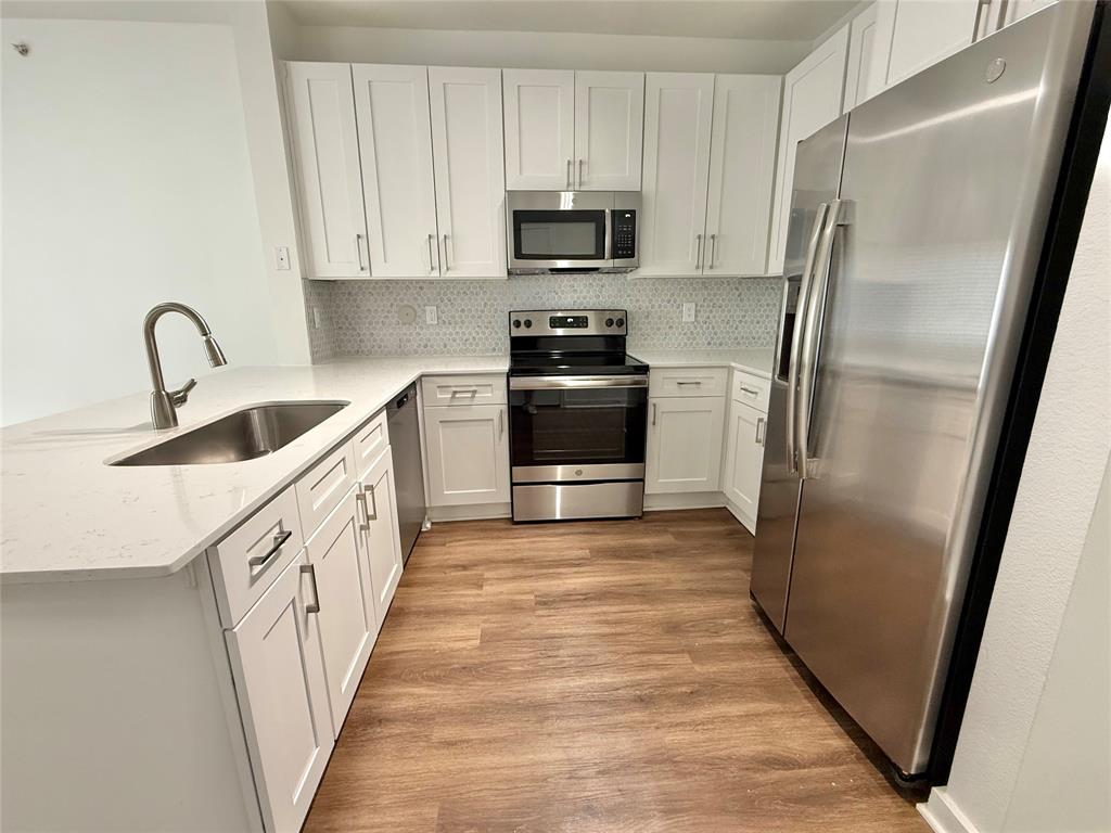 6740 Windhaven Parkway, Unit 5907 The Colony, TX 75056 - Photo 6 of 20 a kitchen with white cabinets and stainless steel appliances