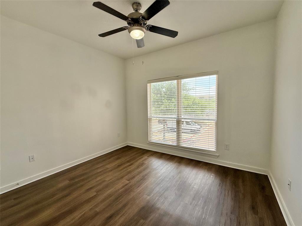 6740 Windhaven Parkway, Unit 5907 The Colony, TX 75056 - Photo 9 of 20 a view of an empty room with wooden floor and a window