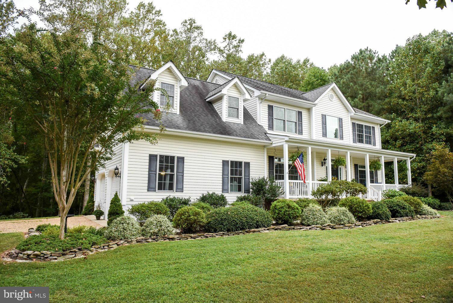 a front view of a house with a yard and trees