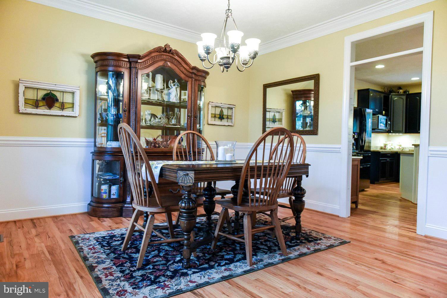 18522 Cherryfield Road Drayden, MD 20630 - Photo 10 of 30 a view of a dining room with furniture wooden floor and chandelier
