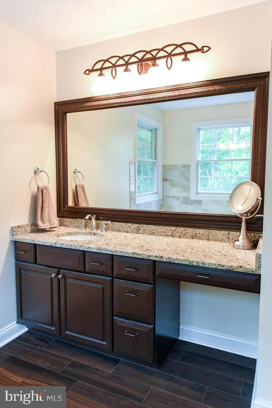 18522 Cherryfield Road Drayden, MD 20630 - Photo 15 of 30 a bathroom with a granite countertop sink and a large mirror