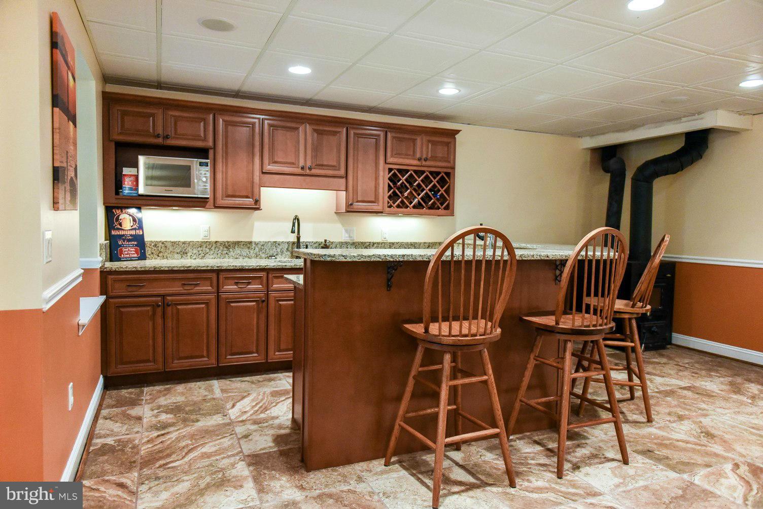 18522 Cherryfield Road Drayden, MD 20630 - Photo 18 of 30 a kitchen with granite countertop a sink cabinets and dining table chair
