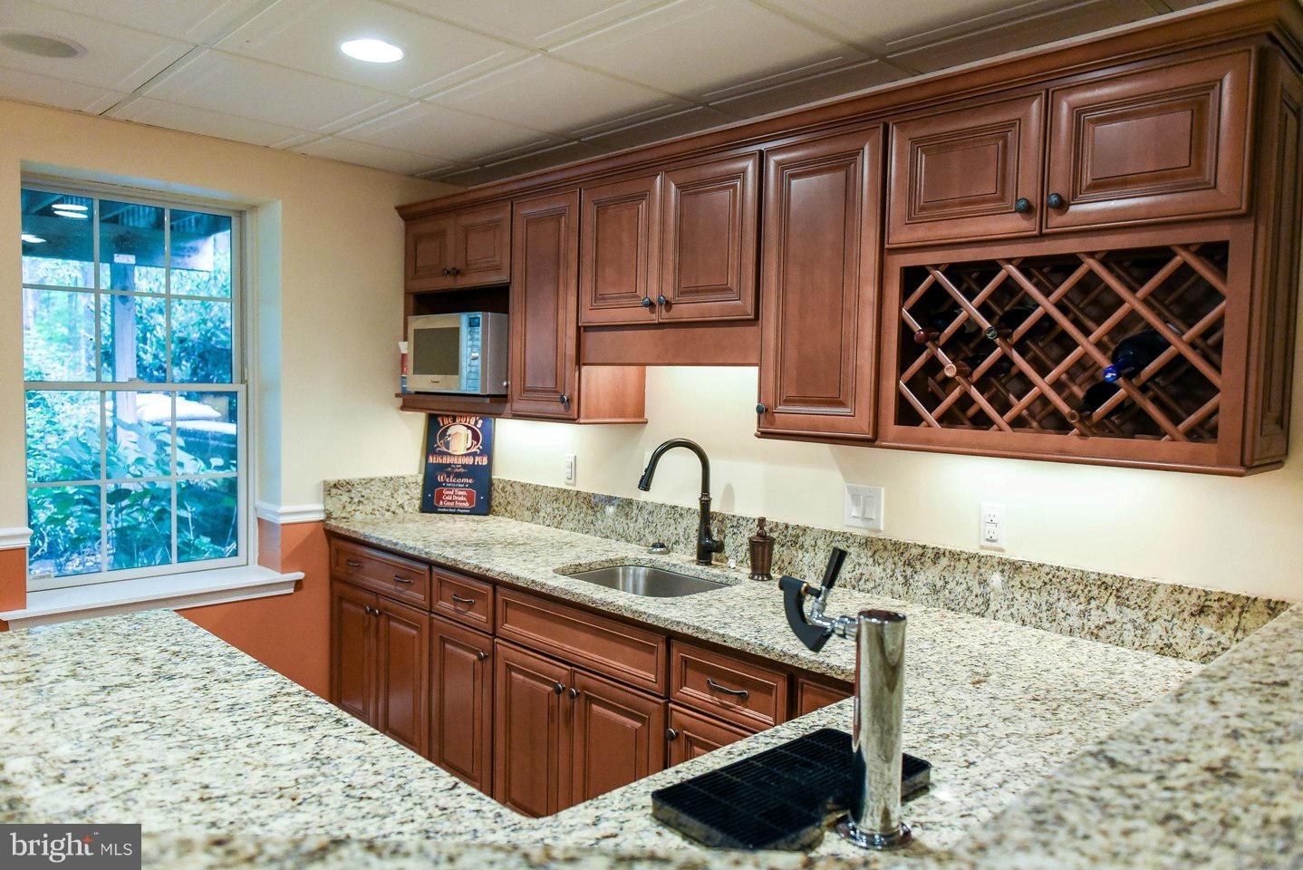 18522 Cherryfield Road Drayden, MD 20630 - Photo 20 of 30 a kitchen with wooden cabinets and sink