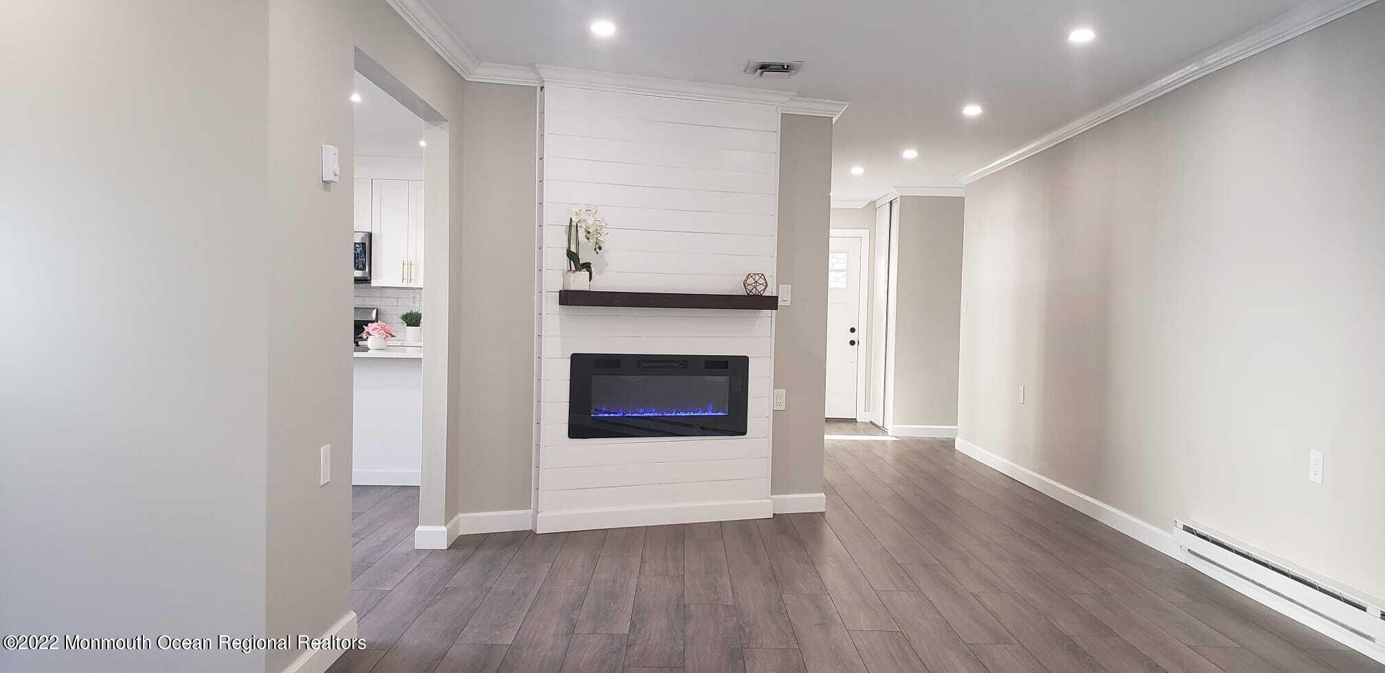 67 Markham Road Brick, NJ 08724 - Photo 8 of 16 a view of a hallway with wooden floor and a fireplace