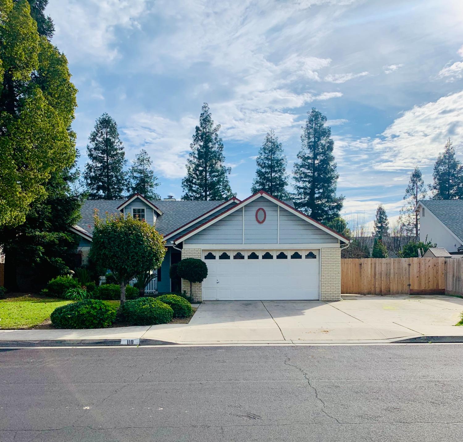 a large house with a yard and wooden fence