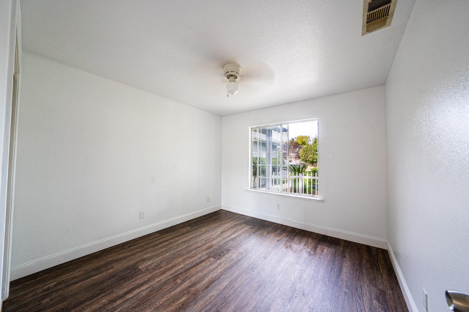 118 Oak Avenue Clovis, CA 93611 - Photo 12 of 22 an empty room with wooden floor and windows