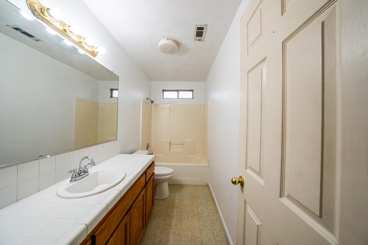 118 Oak Avenue Clovis, CA 93611 - Photo 13 of 22 a bathroom with a double vanity sink a toilet and a mirror