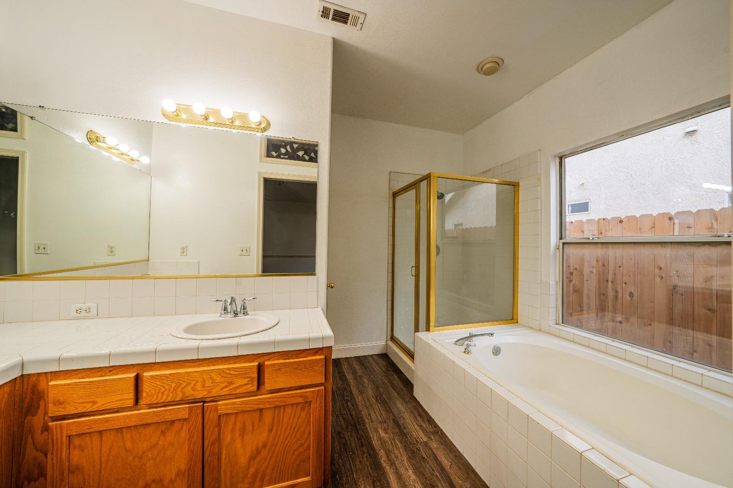 118 Oak Avenue Clovis, CA 93611 - Photo 18 of 22 a bathroom with a tub sink and mirror