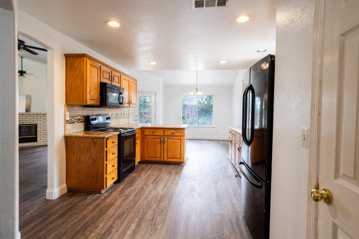 118 Oak Avenue Clovis, CA 93611 - Photo 7 of 22 a kitchen with stainless steel appliances granite countertop a refrigerator a stove top oven a sink and dishwasher