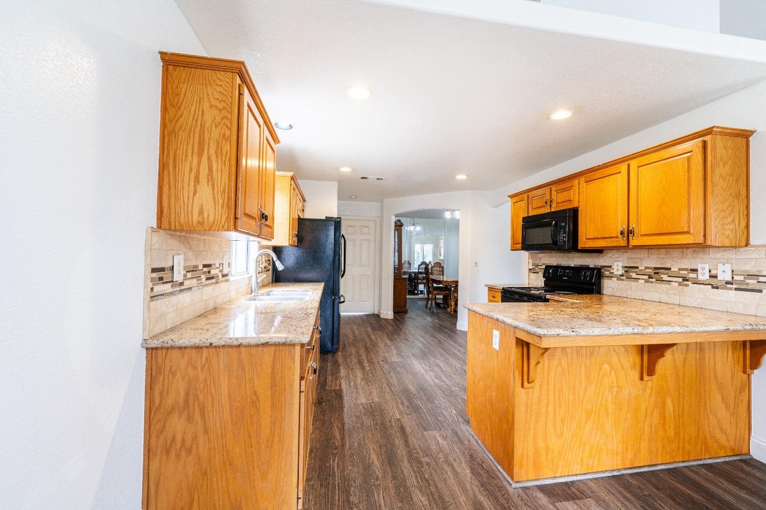 118 Oak Avenue Clovis, CA 93611 - Photo 8 of 22 a kitchen with a sink a counter top space and a window