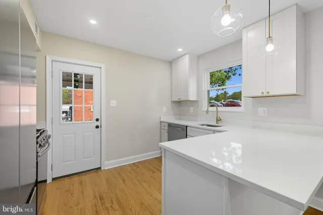 a kitchen with a sink a stove cabinets and counter space