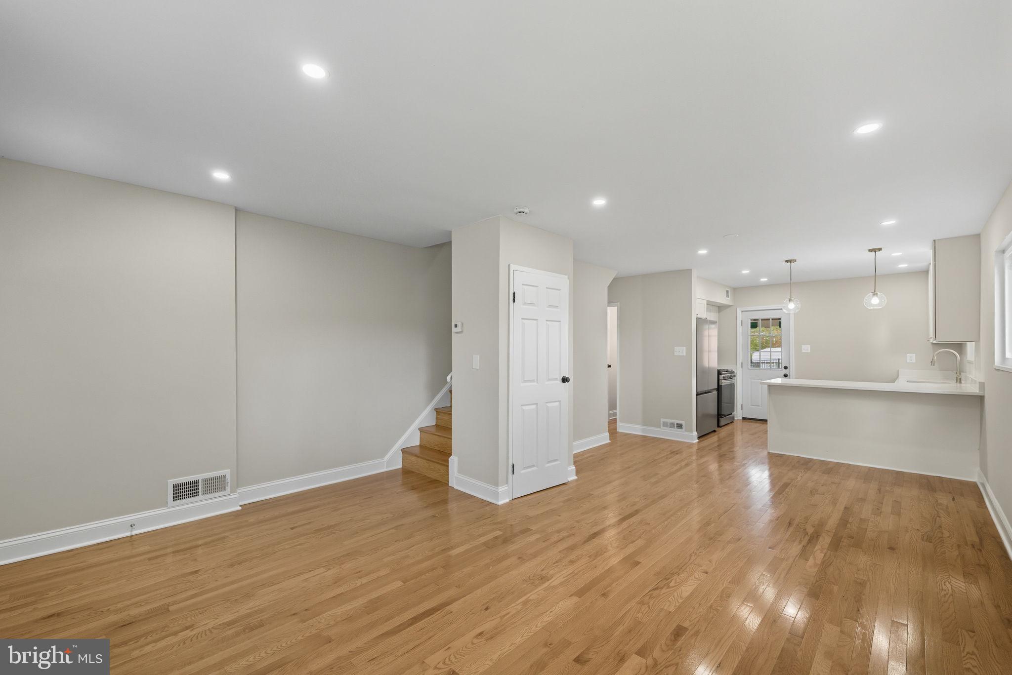 5916 8th Street Northeast Washington, DC 20011 - Photo 5 of 29 a view of an empty room with wooden floor and a kitchen