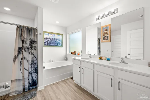 a spacious bathroom with a double vanity sink a mirror and a shower