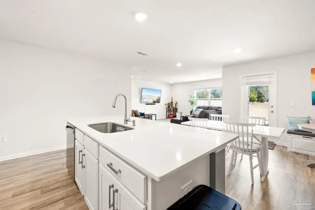 a kitchen with sink stove and wooden floor