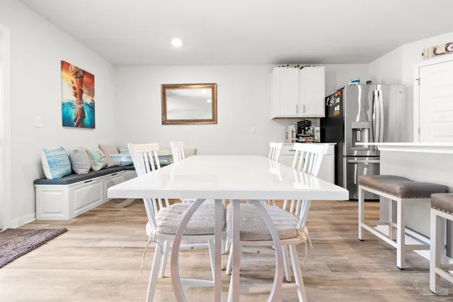 a dining room with stainless steel appliances furniture a large window and a kitchen view