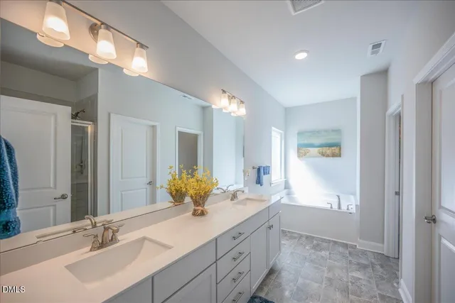 a large bedroom with a bed and wooden floor