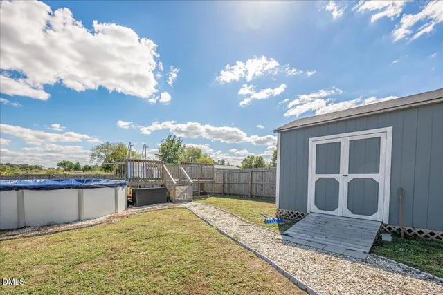 a swimming pool with an outdoor seating and a garden