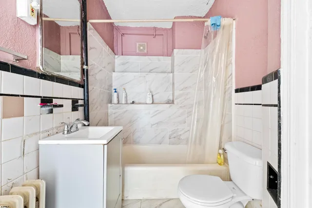 a white toilet sitting next to a small window