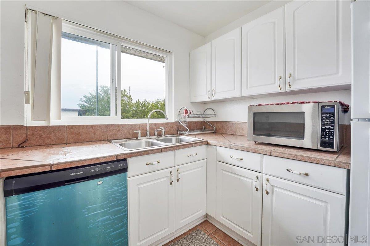 a kitchen with granite countertop white cabinets and a window