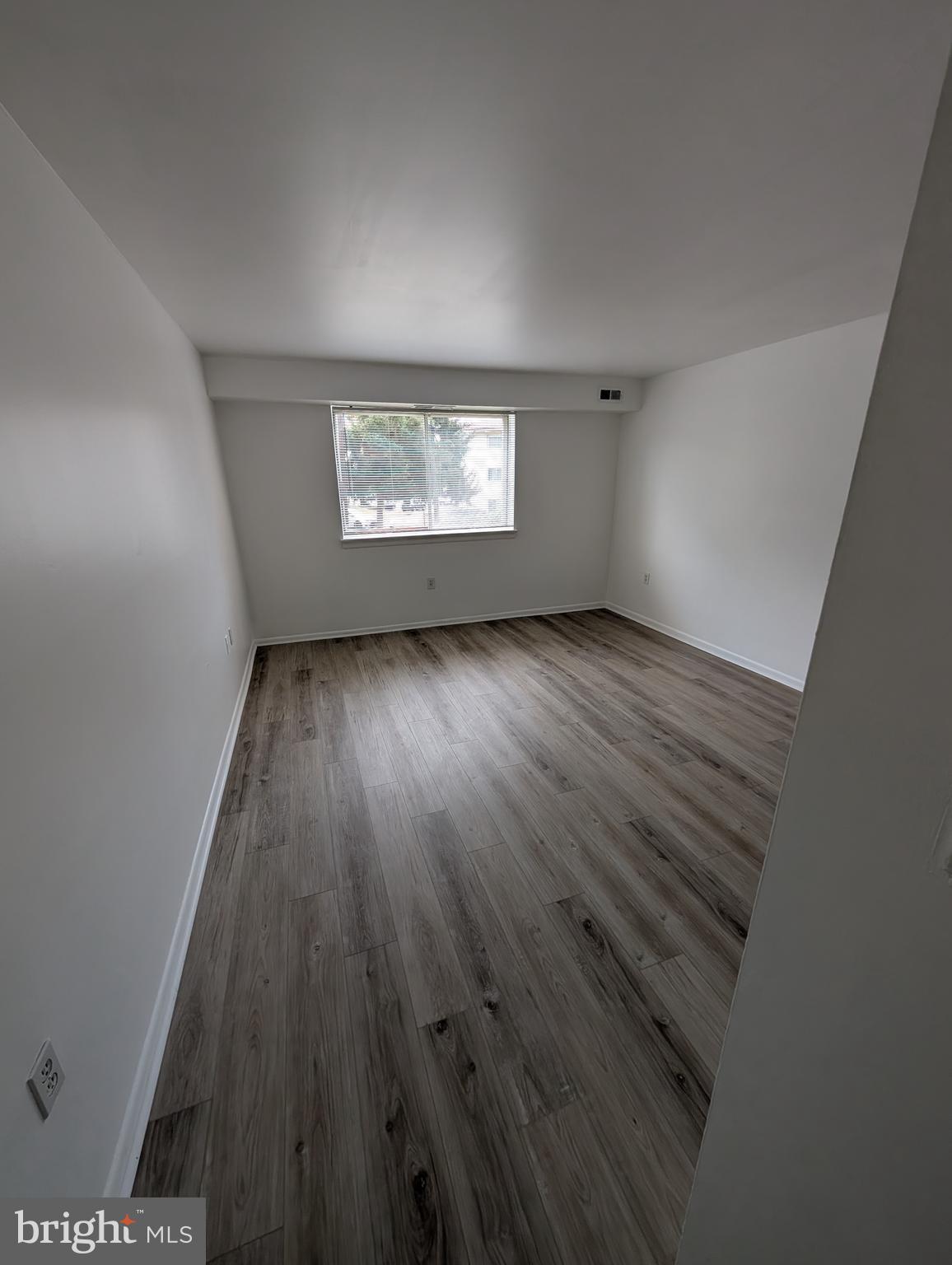 11402 Cherry Hill Road, Unit 103 Beltsville, MD 20705 - Photo 17 of 26 an empty room with wooden floor and windows