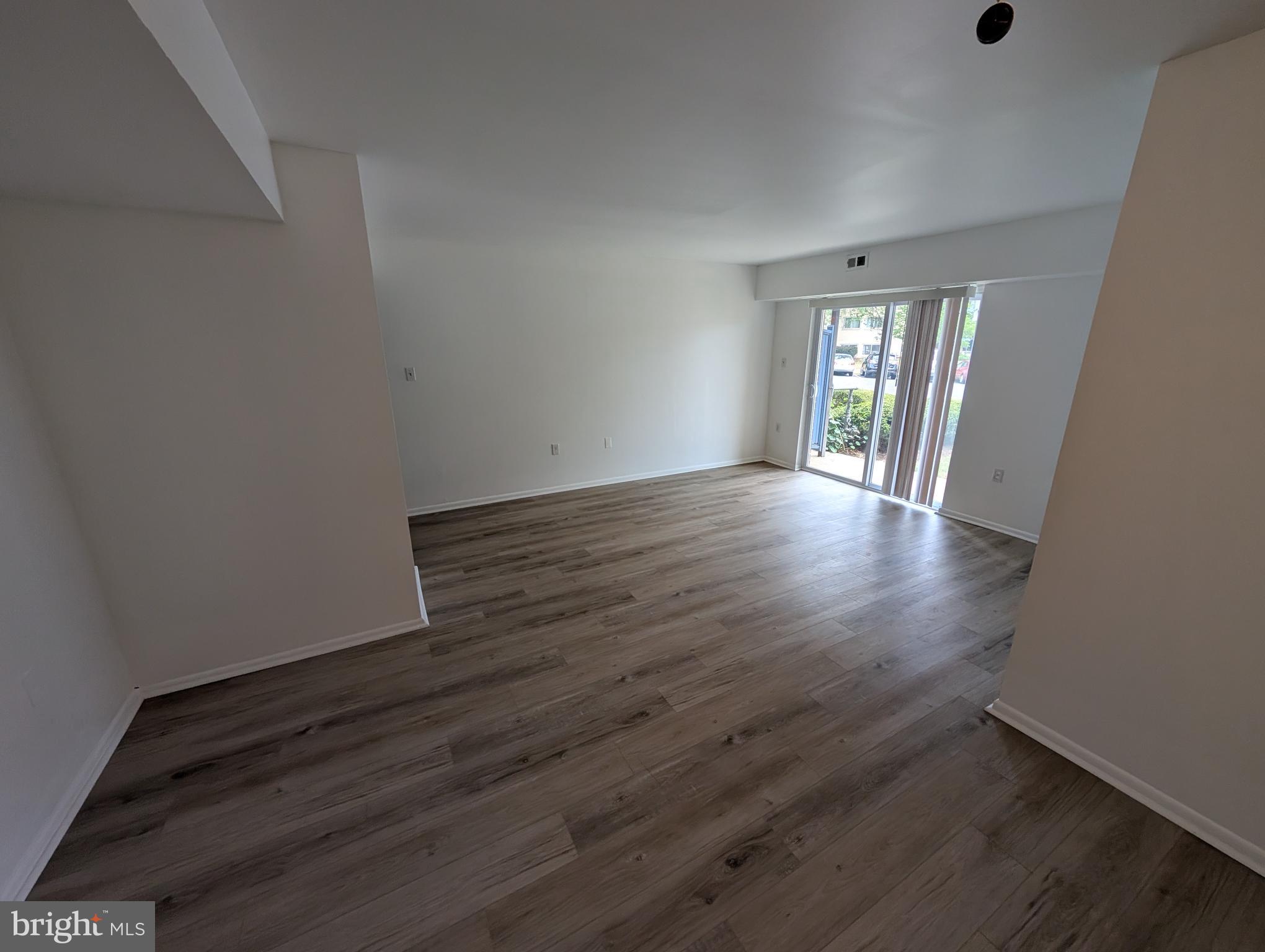 11402 Cherry Hill Road, Unit 103 Beltsville, MD 20705 - Photo 20 of 26 a view of an empty room with wooden floor and a window