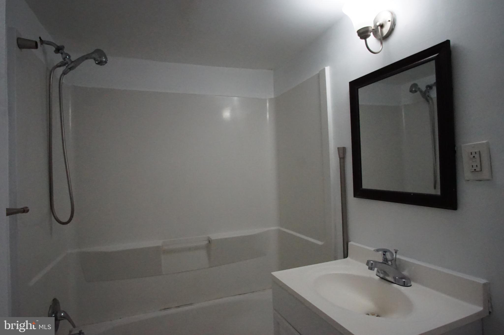 11402 Cherry Hill Road, Unit 103 Beltsville, MD 20705 - Photo 21 of 26 a bathroom with a granite countertop sink a mirror and shower