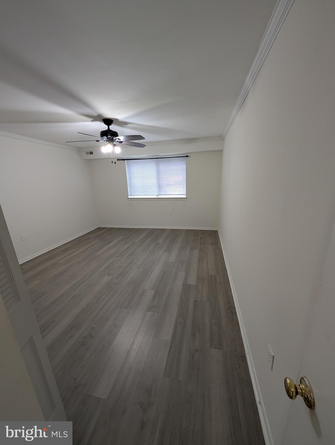 11402 Cherry Hill Road, Unit 103 Beltsville, MD 20705 - Photo 3 of 26 an empty room with wooden floor chandelier fan and windows