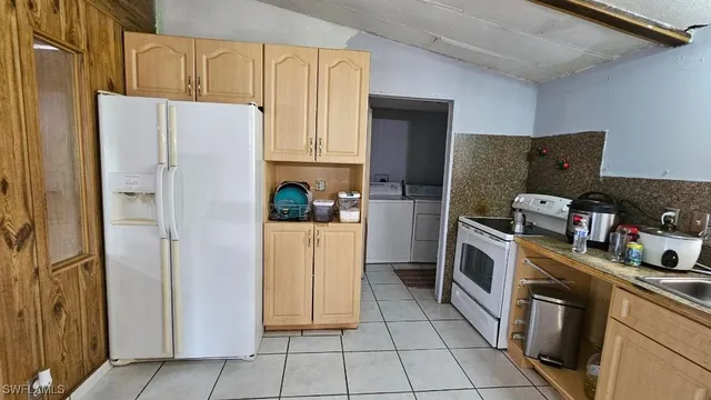 a kitchen with a refrigerator a stove top oven and cabinets