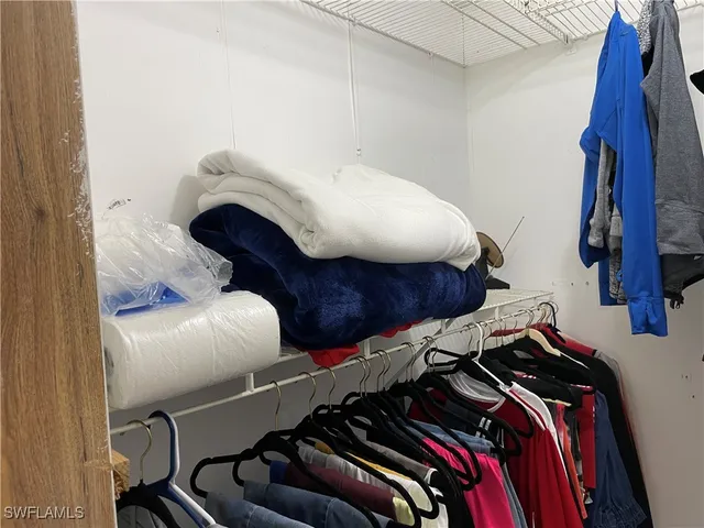 a view of walk in closet with clothes and shoes